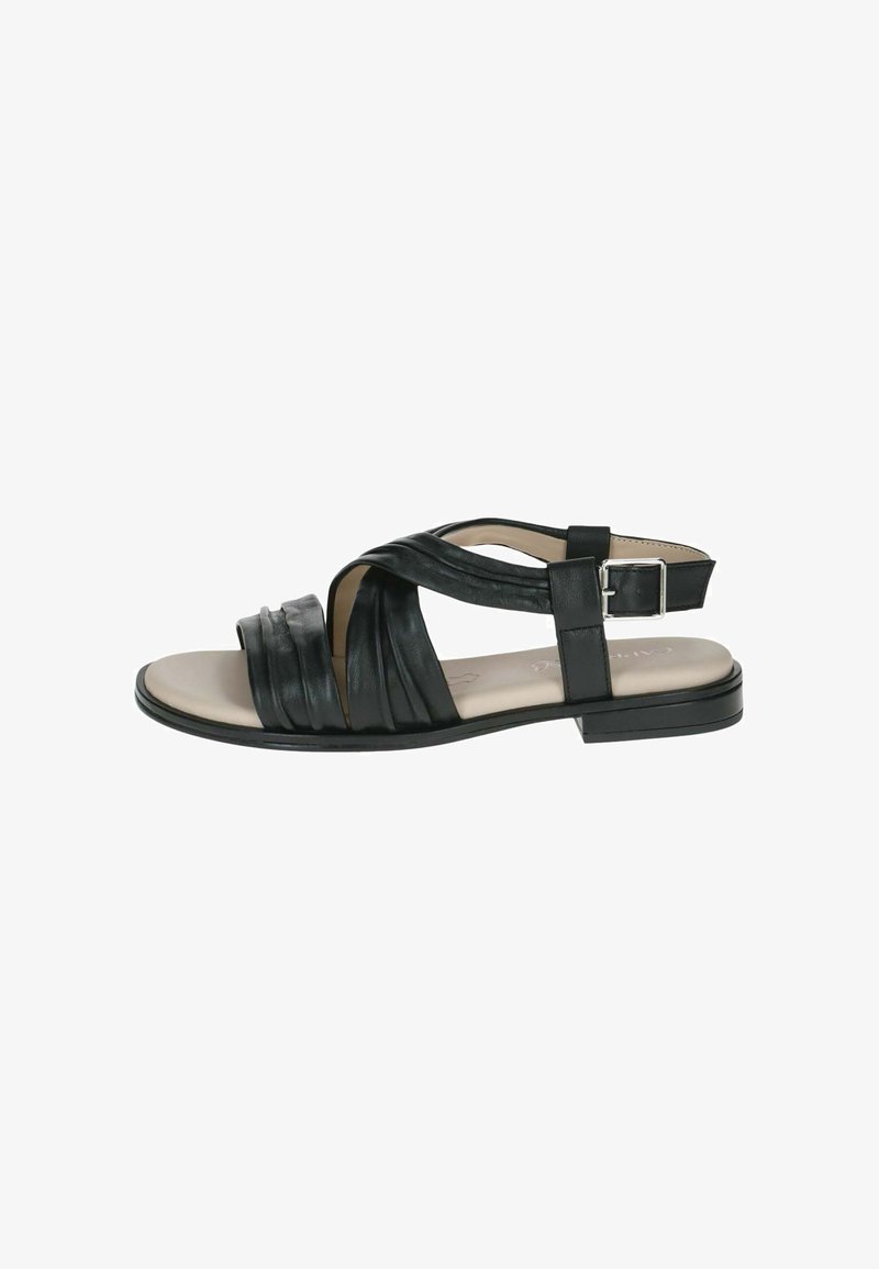 Sandale en cuir noir avec semelle plate, présentant un design à brides croisées, fermeture à boucle, et une texture légèrement brillante sur la partie supérieure.