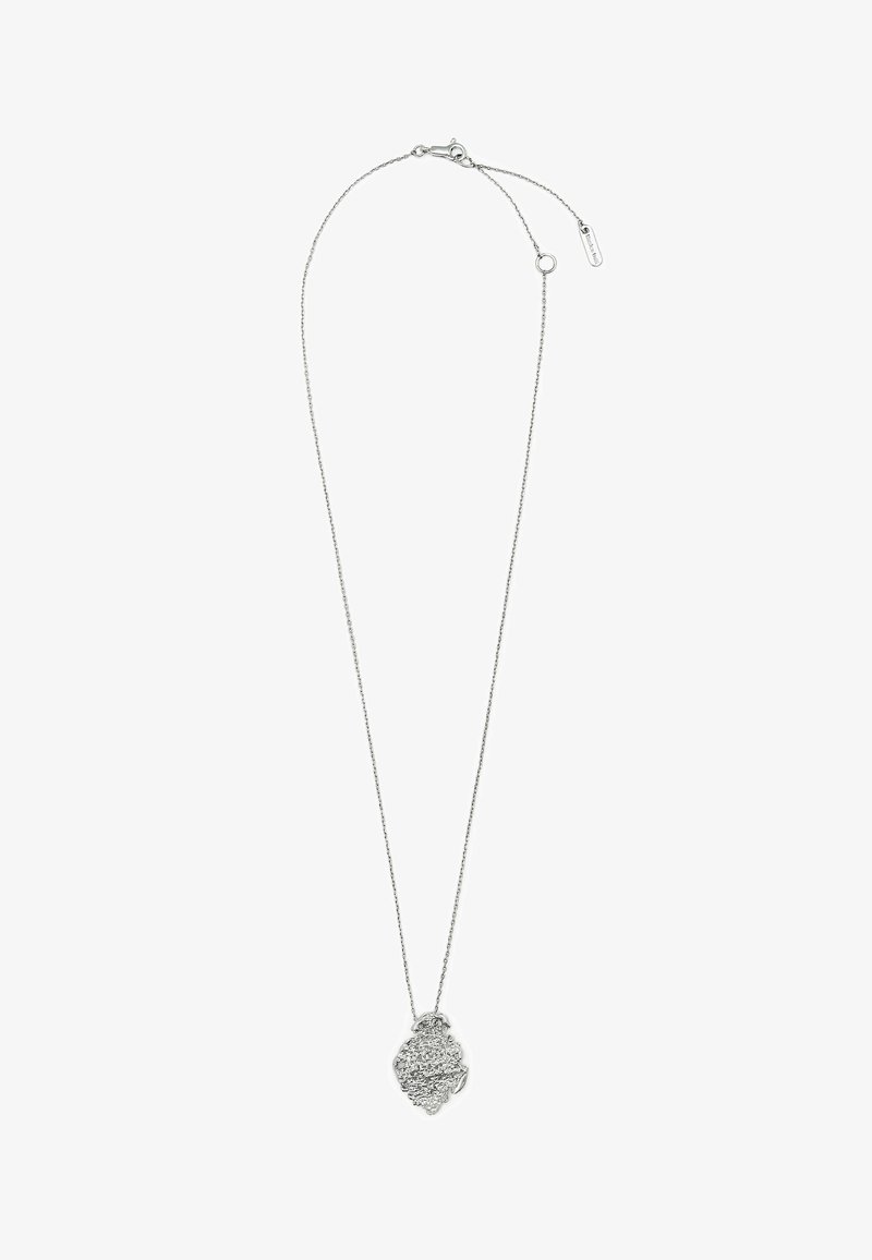 Collier chaîne en argent avec un pendentif texturé abstrait et une petite étiquette près du fermoir sur fond blanc.