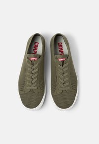 Sneakers verde in mesh con finitura testurizzata, suola piatta in gomma bianca e punta rinforzata. Presentano il logo rosso sulla linguetta.