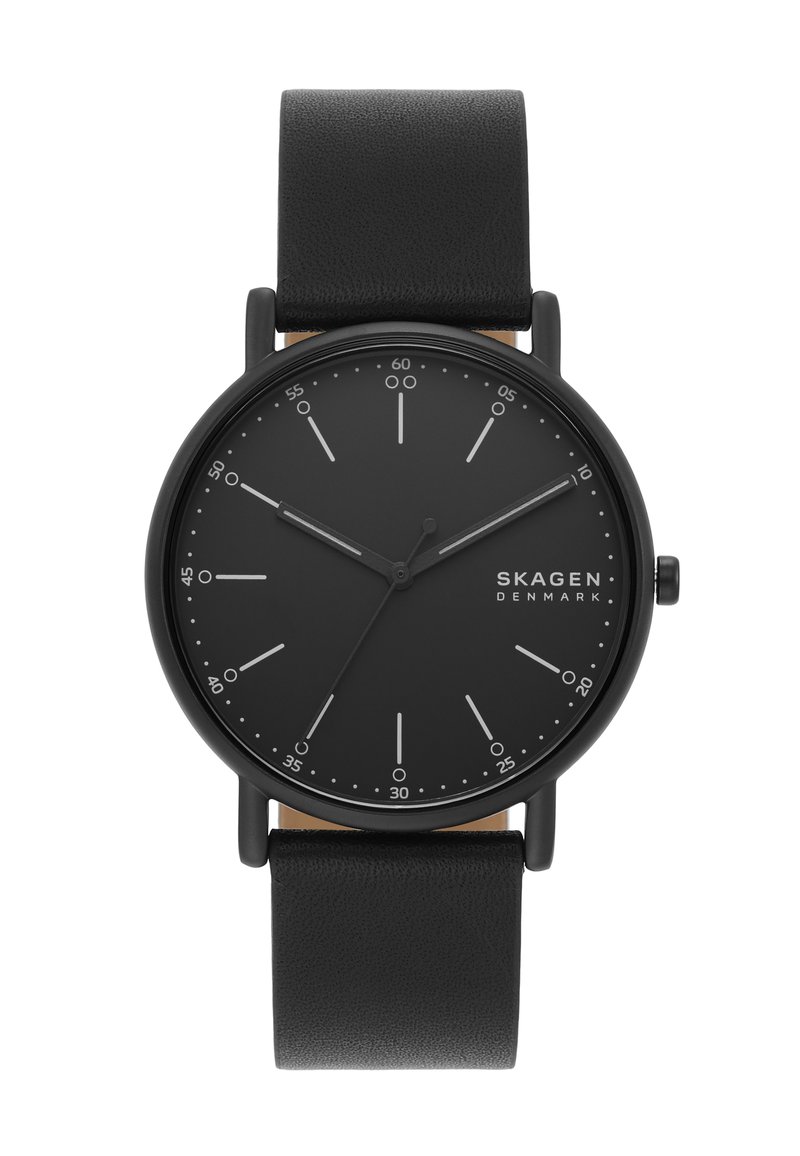 Reloj analógico negro con una caja redonda mate, esfera negra, marcas blancas minimalistas y una correa de cuero negro. No se observan características adicionales.