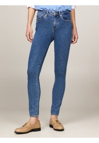 Blå denim skinny jeans med hög midja, fem fickor och en blekt finish. I kombination med ljusbruna loafers.