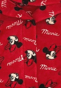 Czerwona tkanina z powtarzającymi się wzorami głów Minnie Mouse oraz imieniem "Minnie" w białym, odręcznym piśmie; miękka tekstura, swobodny design.