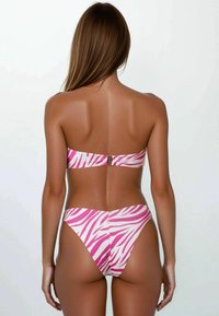 Set bikini in stampa zebra rosa e bianca. Materiale: liscio, leggermente lucido. Top bandeau con gancio. Slip a vita alta con design senza cuciture.