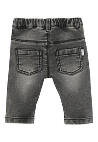 Fioletowe, wyblakłe dżinsy dla małego dziecka z elastycznym pasem i dwiema tylnymi kieszeniami, pokazujące zużytą teksturę i detale przeszyć.