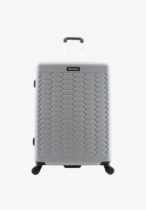 Hard-shell suitcase in silver with a textured hexagonal pattern. Features a retractable handle and four black swivel wheels for mobility.