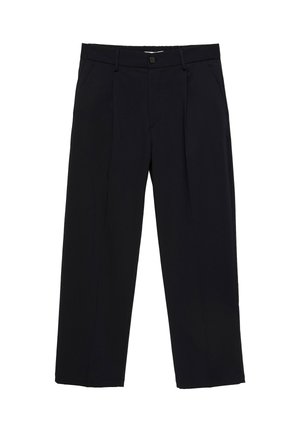 Personne portant un sweat-shirt gris par-dessus une chemise rouge rentrée dans un pantalon noir avec une ceinture noire et une boucle argentée.