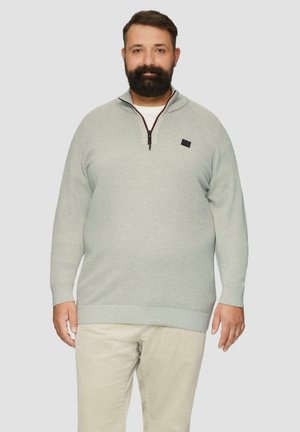 Lichtgroene pullover met een half-rits halslijn en textuurstof. Heeft lange mouwen en een plat gebreide zoom. Inclusief een klein logo-accent.