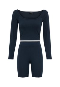 Zestaw dresowy w kolorze granatowym z prążkowanej tkaniny, składający się z krótkiej bluzki z długim rękawem oraz spodenek sięgających do połowy uda, o dopasowanym kroju i elastycznym materiale.