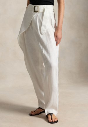 Biele široké nohavice s vysokým pásom, asymetrickým predným záhybom a látkovým opaskom, nosené s čiernymi žabkami a čiernym topom.