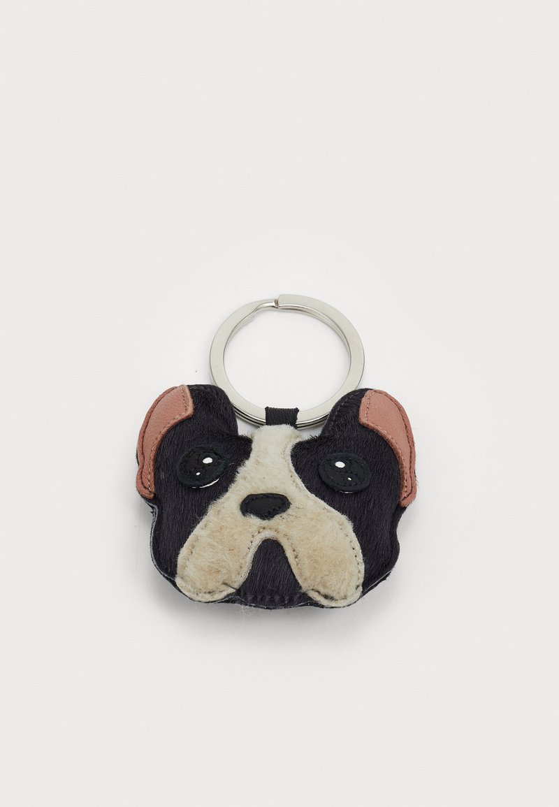 Um porta-chaves em forma de cabeça de cão, apresentando pelo preto, focinho bege e detalhes em rosa nas orelhas, com um anel de metal para fixação.