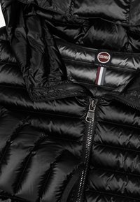 Giubbotto imbottito nero con tessuto lucido, design trapuntato orizzontale, chiusura frontale con zip e cappuccio. Presenta un logo Colmar all'interno.