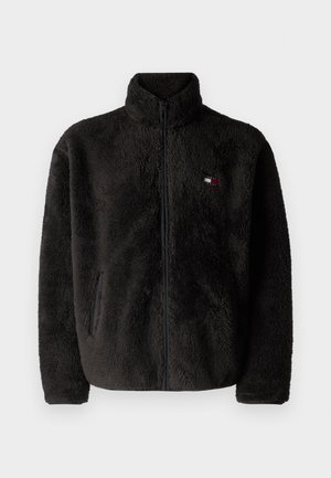 Tumehall fleece jakker kõrge kraega, esisepp ja küljetaskud. Omab rindkerel väikest logopatchi punases, valges ja sinises.