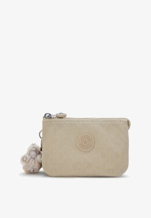 Funda de nylon beige con un acabado texturizado, que cuenta con un cierre de cremallera, un acento con el logo y un llavero decorativo de un mono de peluche adjunto.