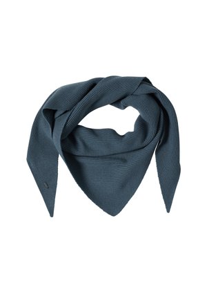 Vrouw draagt een wit shirt met lange mouwen, blauwe denim spijkerbroek en een blauw gestructureerde driehoekige sjaal om haar nek.