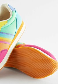 Adidași colorați cu un design gradient în nuanțe de albastru, galben și roz. Părți superioare din țesătură, tălpi din cauciuc texturat și un accent cu dungi multicolore.