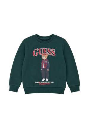 Felpa verde scuro con un orso che indossa una giacca a quadri rossa, scarpe bianche e un cappello rosso, con testo "GUESS" e "Los Angeles Est. 1981 California."
