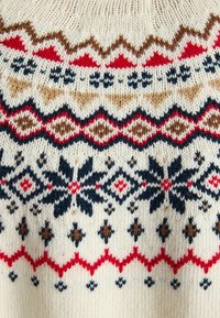 Pletený sveter s krémovým základom, zdobený červenými, modrými, hnedými a čiernymi geometrickými vzormi. Výrazné motívy snehovej vločky a diamantu.