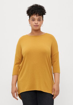 Mustard yellow, loose-fitting top with a Scoop neckline and three-quarter sleeves. Soft texture and curved hemline for relaxed style.