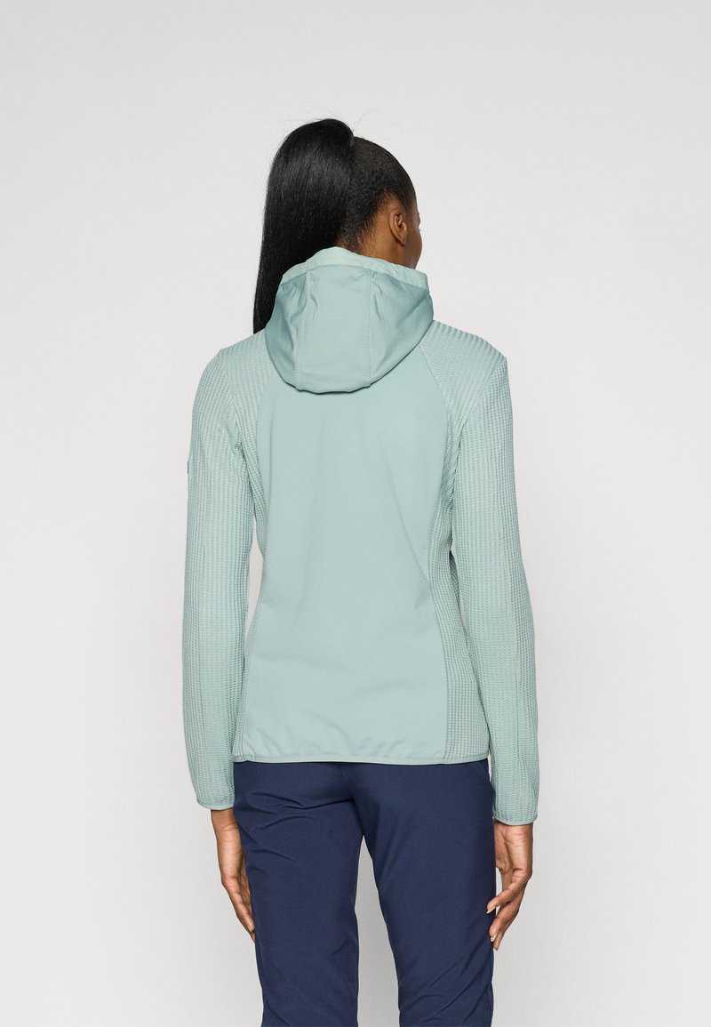 Hellblaues, tailliertes Jackett mit einem strukturierten, gerippten Design an den Ärmeln, einer Kapuze und glattem Oberstoff; kombiniert mit marineblauen Hosen.