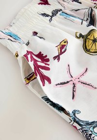 Valged kangast lühikesed püksid, millel on värvikad mere-teemalised trükised, sealhulgas kalad, korallid ja tähed. Elastne vöökoht volditud detailidega.