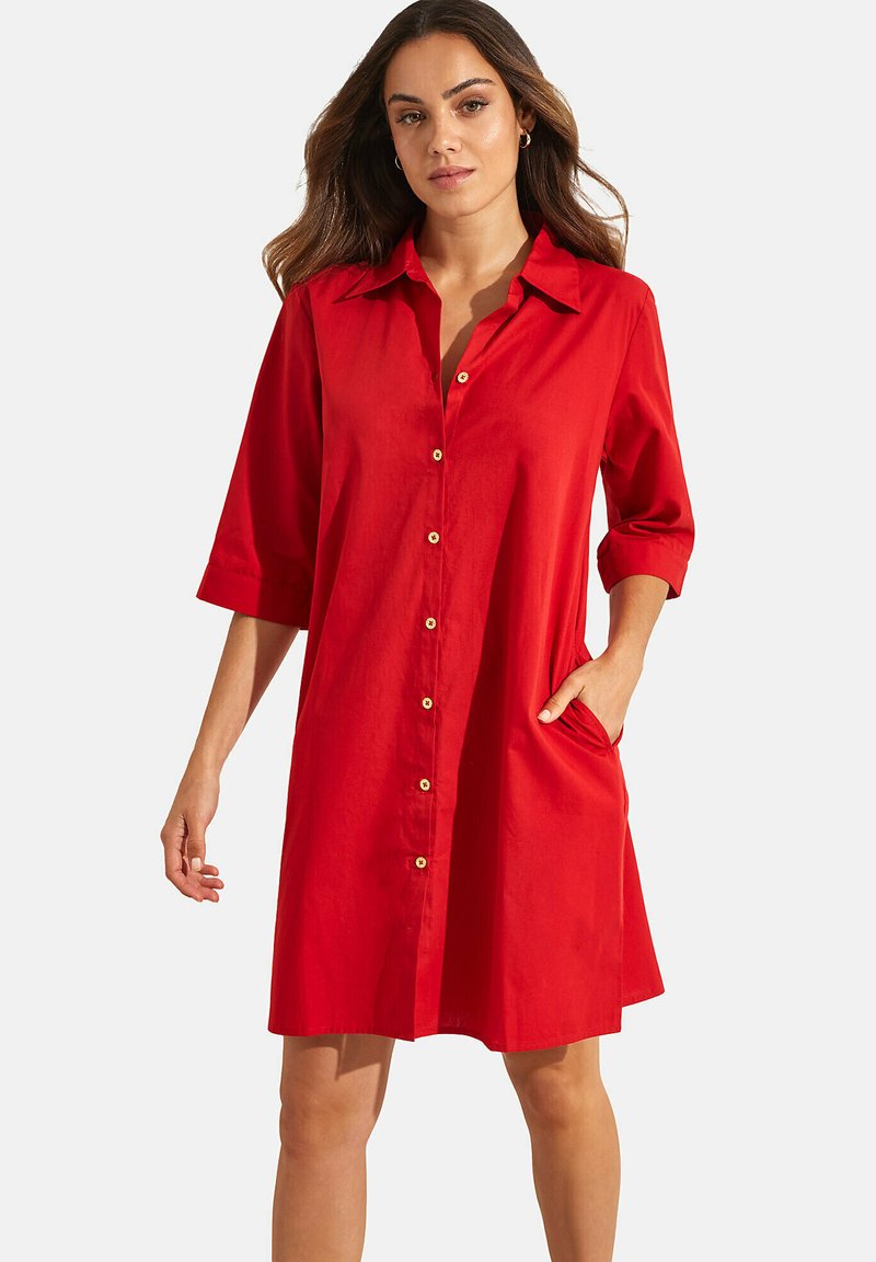Robe rouge à boutons, faite d'un tissu léger, avec un col, des manches trois-quarts et des poches latérales, offrant une coupe décontractée et droite.