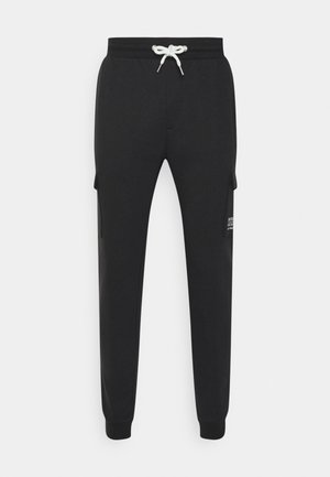 Black sweatpants made of soft fabric, featuring a drawstring waist, side cargo pockets, and tapered legs with ribbed cuffs.
