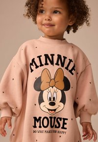 Rosa oversized sweatshirt med svart text och en grafisk bild av Minnie Mouse med en brun rosett, dekorerad med små hjärtan.