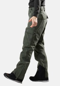 Olijfgroene cargo broek met meerdere zijzakken, versterkte stiksels, ritsventilatiegaten en een logo op de dij. Gemaakt van duurzaam materiaal.