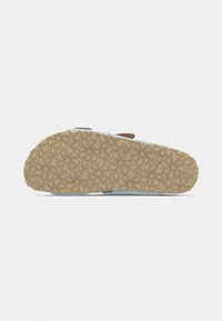 Chaussures bleu clair avec une semelle en caoutchouc texturée présentant un motif géométrique et une sangle ajustable marron. Matière supérieure lisse.