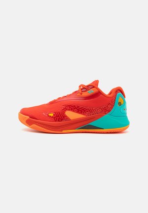 Zapatilla deportiva roja con una parte superior texturizada, acentos naranjas y un talón turquesa. Presenta un lado estampado y una suela de goma para mayor agarre.