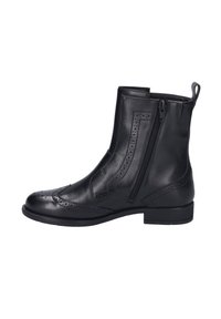Bottine en cuir noir avec perforations décoratives, fermeture éclair sur le côté, petit talon, texture lisse et éléments de design structurés.