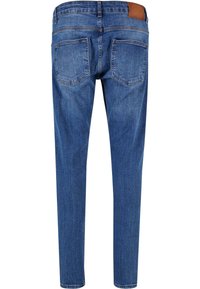 Jeans de denim azul con un diseño ajustado, que cuentan con dos bolsillos traseros y un parche de cuero marrón en la cinturilla. Textura suave.