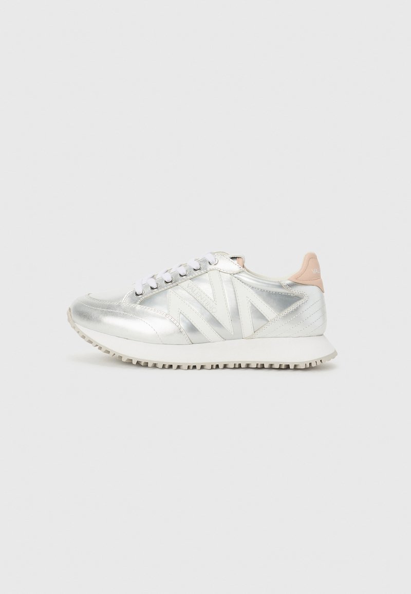 Silberne synthetische Sneakers mit weißen Schnürsenkeln und einer hellrosa Ferse, ausgestattet mit einer strukturierten Sohle und kantigen Designelementen an den Seiten.