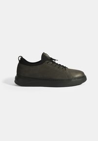 Grijze leren sneaker met een ronde neus, zwarte rubberen zool, klassieke vetersluiting en minimale stiksels aan de zijkanten.