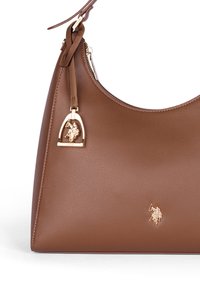 Borsa a spalla in pelle marrone con finitura texture, caratterizzata da un accento in logo dorato e una tracolla rimovibile. Forma curva con chiusura a zip.