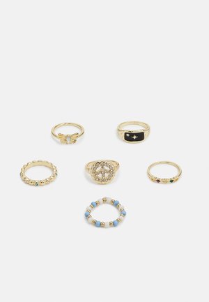 Conjunto de seis anéis dourados: um com design de borboleta, outro com esmalte preto e estrela, redondo texturizado, padrões de contas e realces de pedras preciosas.