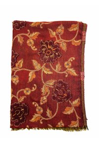 Couverture tissée rouge avec broderie florale en violet et orange. Finition avec des bords frangés et des détails sophistiqués le long de la bordure.