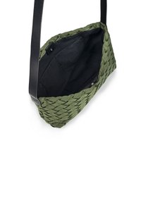 Borsa intrecciata verde con una superficie texturizzata, dotata di una tracolla in pelle nera e di un ampio interno nero con una tasca.