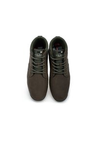 Bruna syntetiska skor med snörning, vadderad krage och texturerad yta. Inuti finns en rutiga foder och logotypdetalj.