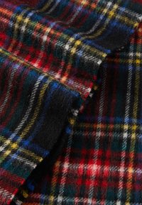 Tessuto plaid in lana caratterizzato da modelli rossi, neri, blu e gialli. Texture morbida con un classico design tartan e fibre di lana visibili.