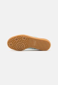 Gummisohle in Beige mit strukturiertem Griffmuster. Verfügt über kreisförmige und punkteförmige Akzente. Obermaterial aus synthetischem Material in Hellblau und Weiß.
