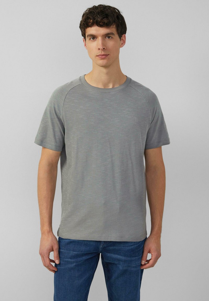 Szary t-shirt z krótkim rękawem o okrągłym dekolcie i teksturowanej tkaninie. Ma rękawy raglanowe oraz delikatne detale w poziome wzory.