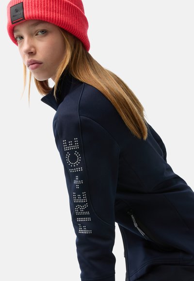 Navy fleece jacket with high collar, featuring shiny rhinestone design on the left sleeve and zippered pockets on the sides.