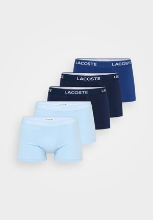 Pet boxer gaće Lacoste v svetlo modri, temno modri in kraljevo modri barvi, razporejene v zamaknjenem vrstnem redu na beli podlagi.