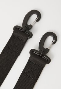 Svarta nylonremmar med metallsnappar i varje ände, placerade mot en vit bakgrund, som visar hållbarhet och funktionalitet.