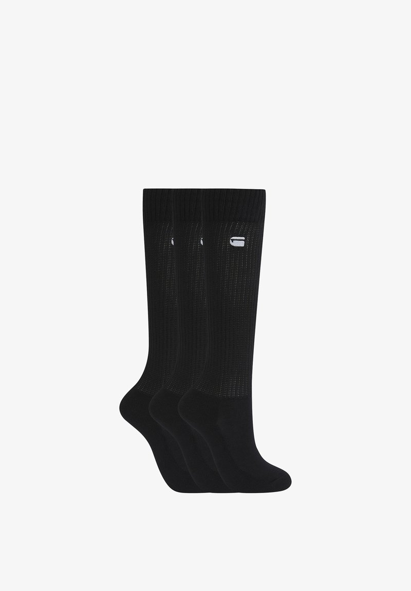 Trois paires de chaussettes noires montantes avec une texture côtelée et un petit logo blanc près du revers supérieur, affichées côte à côte sur fond blanc.