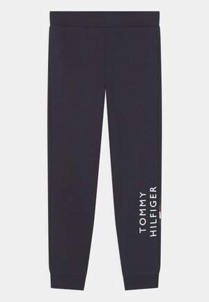 Czarne spodnie dresowe z elastycznym pasem i mankietami, z białym tekstem i logiem "Tommy Hilfiger" na prawej nodze.