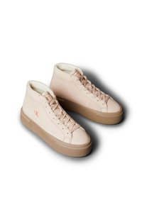 Beige hoge sneakers van leer met een gladde textuur, voorzien van een veterontwerp, een rubberen zool en een klein rood logo aan de zijkant.