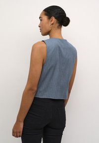 Top blu a righe senza maniche con un design cropped, realizzato in tessuto leggero, con un colletto pulito e una texture liscia.