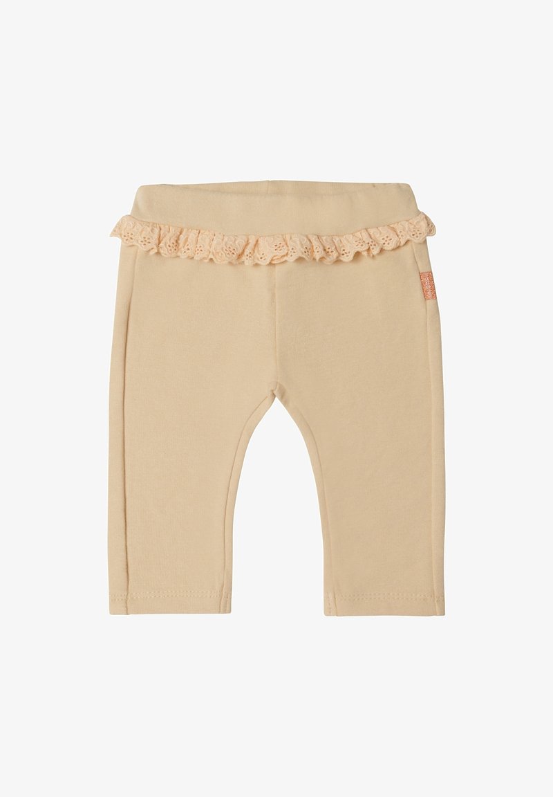 Leggings bébé beiges avec taille élastique et un volant en dentelle décoratif autour de la taille.
